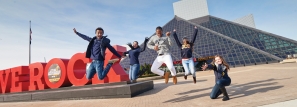 JCU students jumping in front of 'WE ROCK" sign