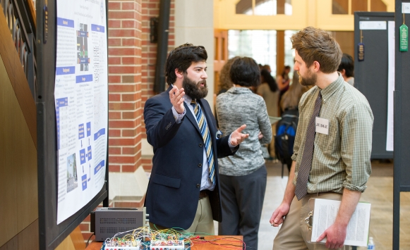 Brad Doughty (left) discusses his senior project at the Celebration of Scholarship poster session.