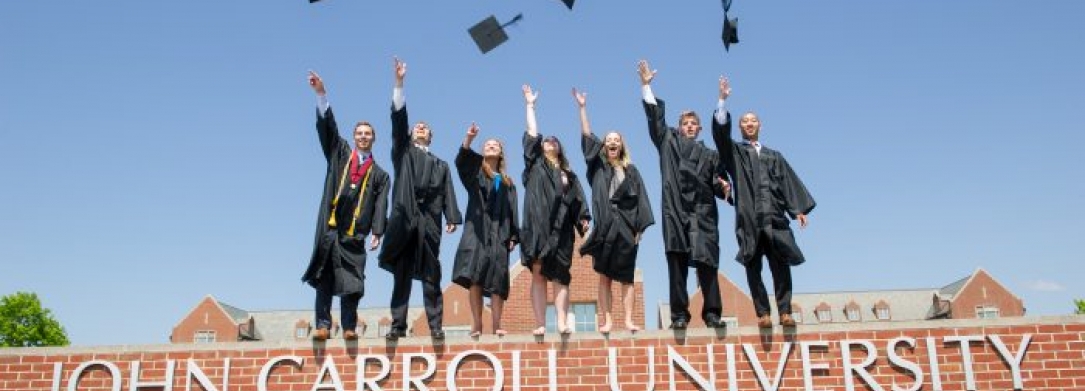 Picture of JCU celebrating graduation by throwing their caps in the air