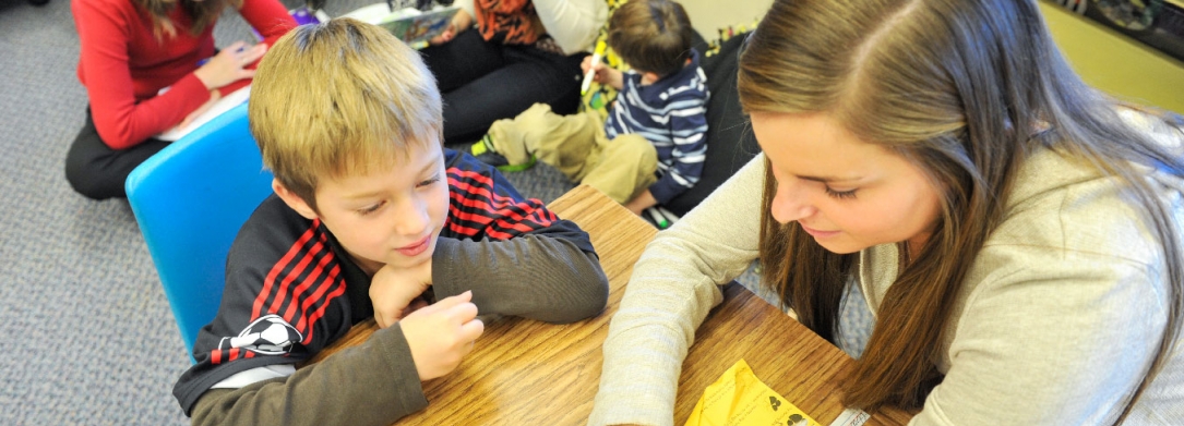 A teacher reading to a student