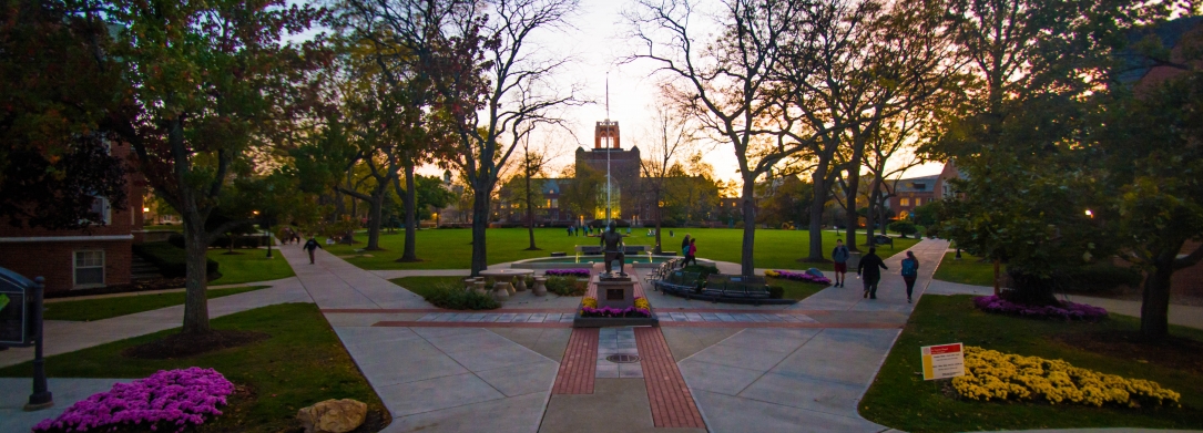 Image taken at dusk of the St. Ignatius statue and quad from the front steps of the Student Center