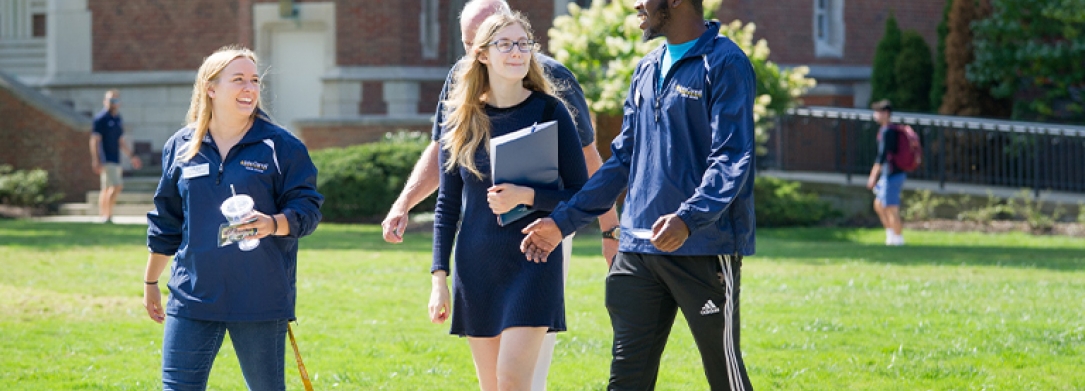 Two JCU student tour guides giving a tour to a high school student and her family