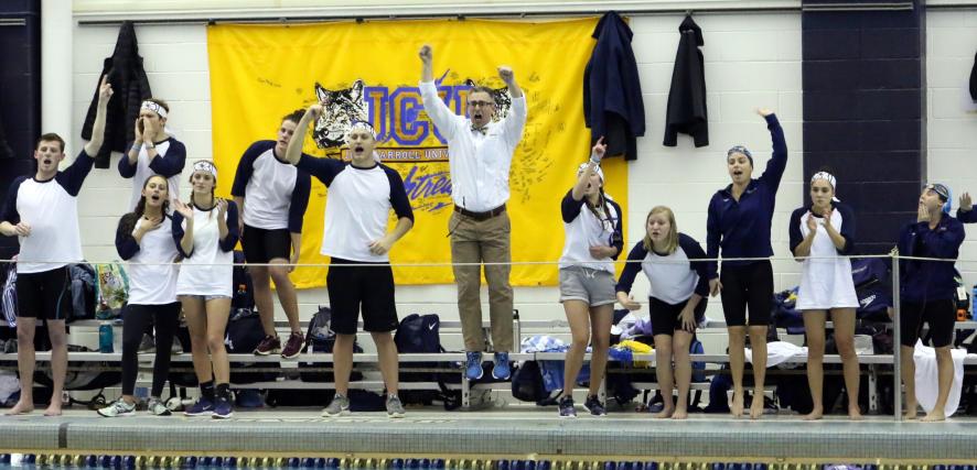 Mark Fino and his swimmers celebrate on the deck as JCU wins a race