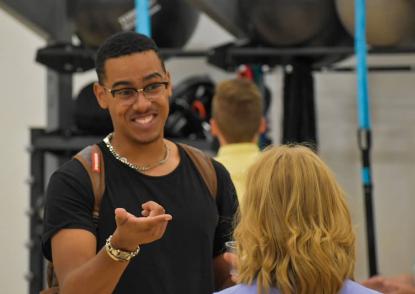 Male student laughs with a staff member