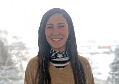 Nicole Saluan smiles in from of a wintery scene