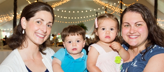 two women holding children at alumni weekend