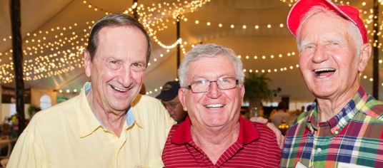 three male alumni smiling a reunion